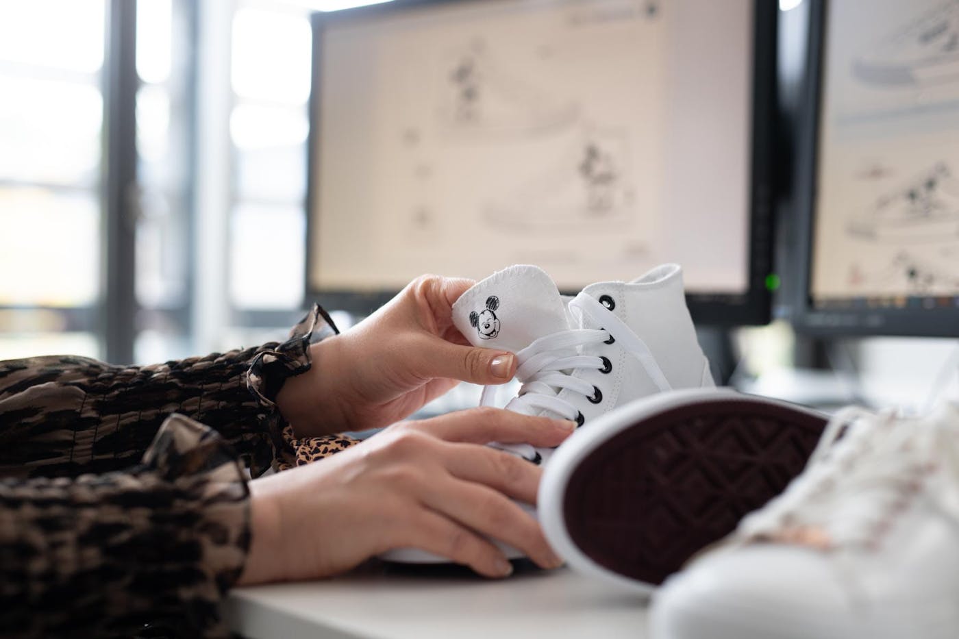 Weisser High-Top-Sneaker mit Mickey-Mouse-Motiv am Arbeitsplatz