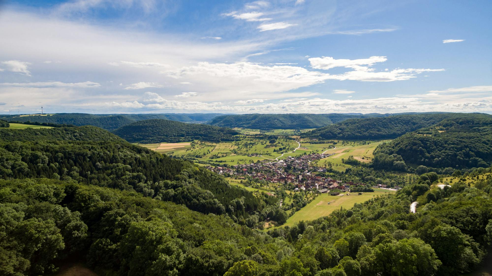 Panorama des Murrtals mit Dorf, Feldern und bewaldeten Hügeln